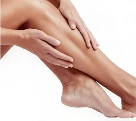 Närbild av hand som applicerar BTL EXILITE IPL-behandling på patientens ben.