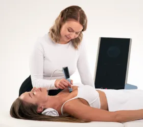 Patient mottar BTL EXION estetisk behandling på ansiktet med handhållen applicerare.