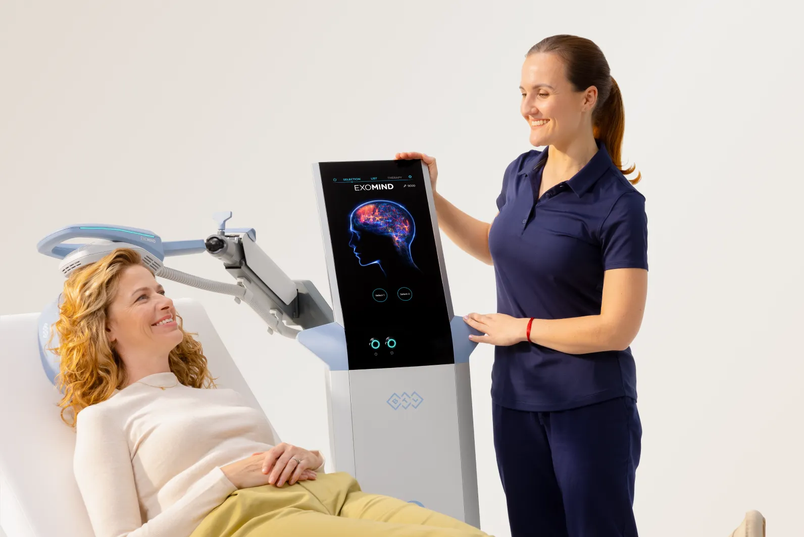 Sjukskoterska presenterar BTL EXOMIND-skarm for patient under hjärnstimulering-behandling i klinisk miljö.