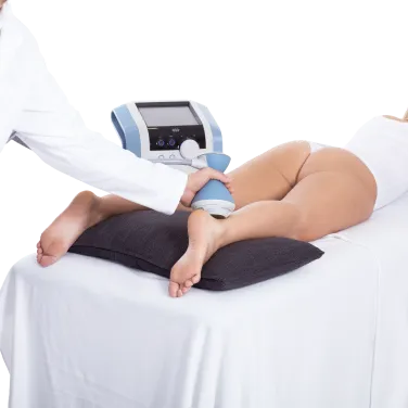 Patient genomgår BTL Focused Shockwave stötvågsterapi på underbenet med en elektroakustisk handapplikator.