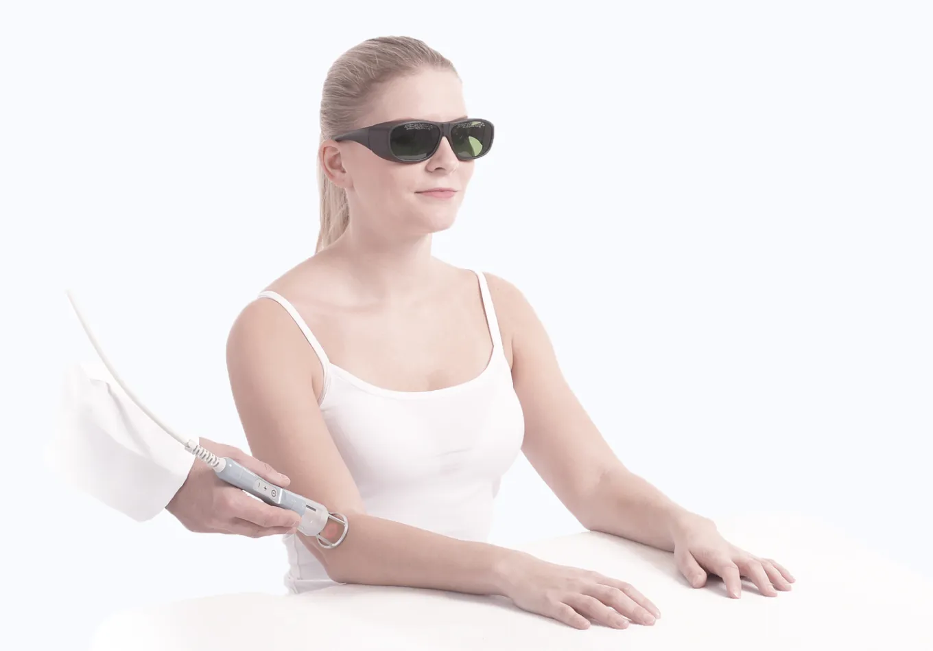 Patient mottar laserterapi med BTL High Intensity Laser-system, bärande skyddsglasögon under behandling.