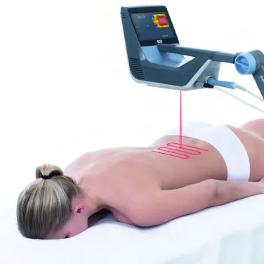 Patient i prone position mottar laserterapi på ryggen med BTL High Intensity Laser-systemet, vilket demonstrerar robotiserad