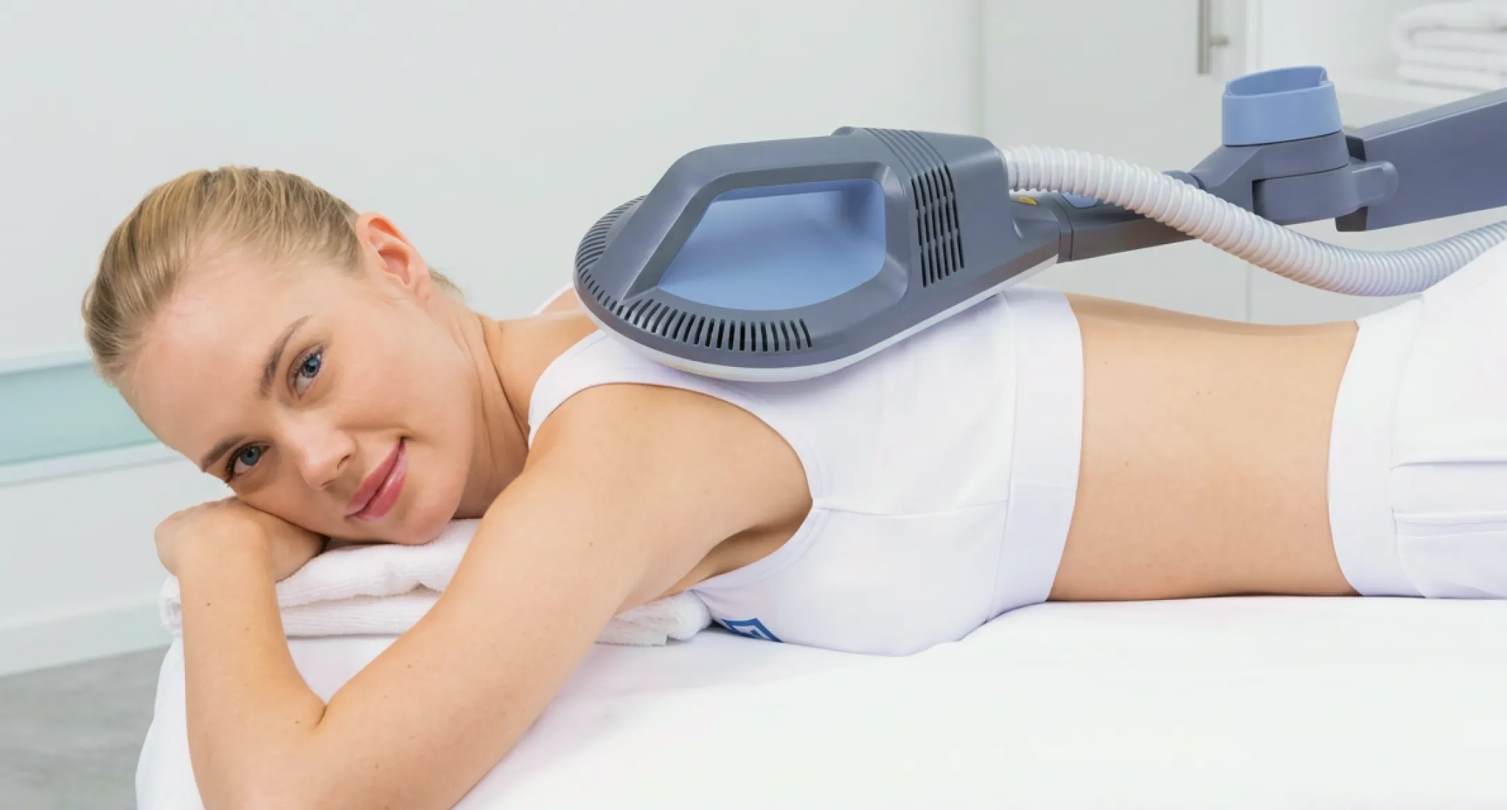 Patient liggande under behandling med BTL Super Inductive System, elektromagnetisk terapi-apparat med automatiserad arm