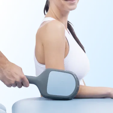 Kliniker applicerar BTL Super Inductive System DUO-behandling på patientens arm med elektromagnetisk terapi genom applikator.