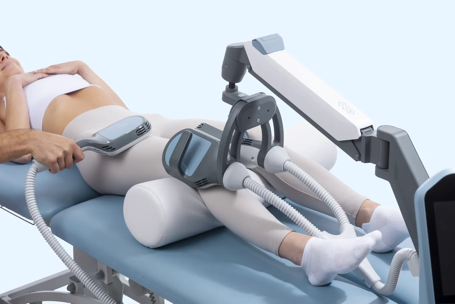 Patient genomgår behandling med BTL Super Inductive System DUO-applikatorer placerade på benet för elektromagnetisk terapi.