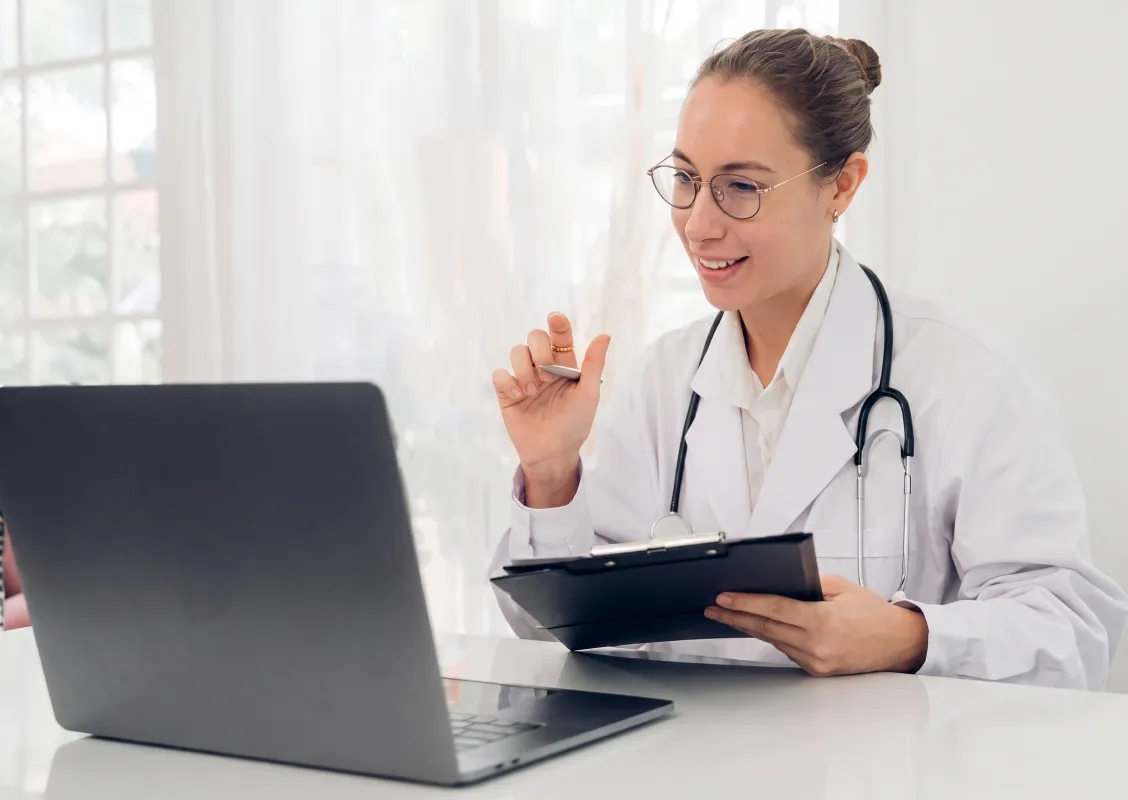 Klinikpersonal använder dator för BTL-systemstöd under patientkonsultation (stöd, service).