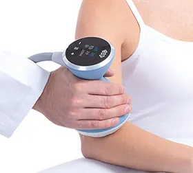 Handheld medical device pressed against a person's upper arm during a health exam.
