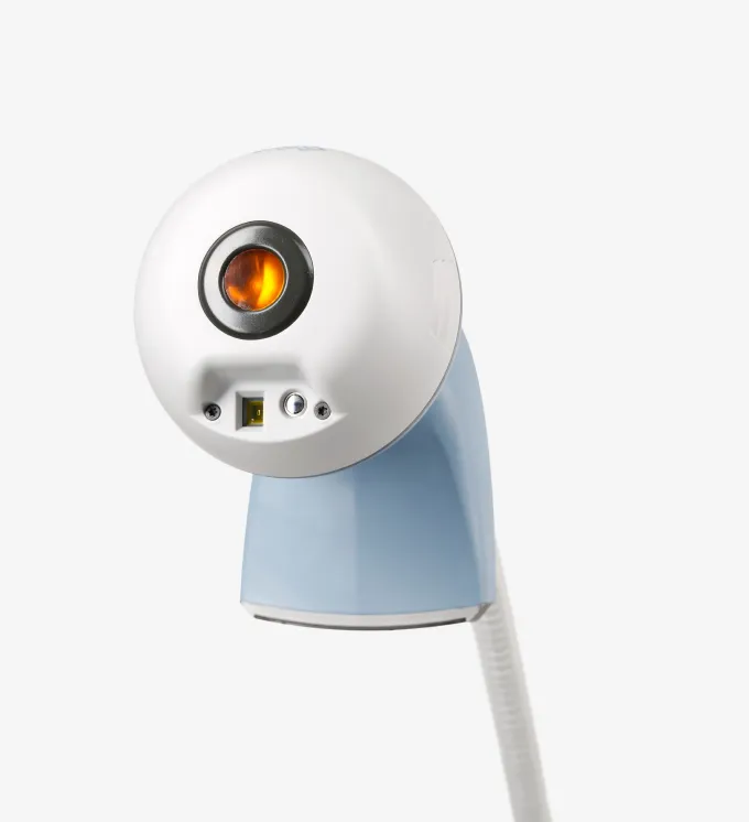Handheld skin care device with circular orange light on white and blue body.