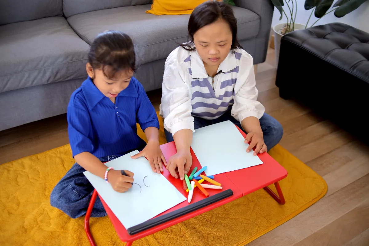 Two Asian girls in Singapore drawing together, practising giving each other kind, useful feedback