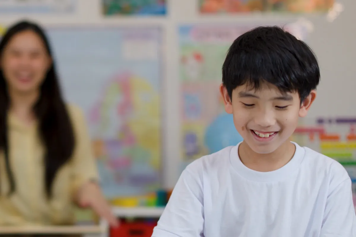 A confident young Asian boy speaking up in a Singapore primary school classroom