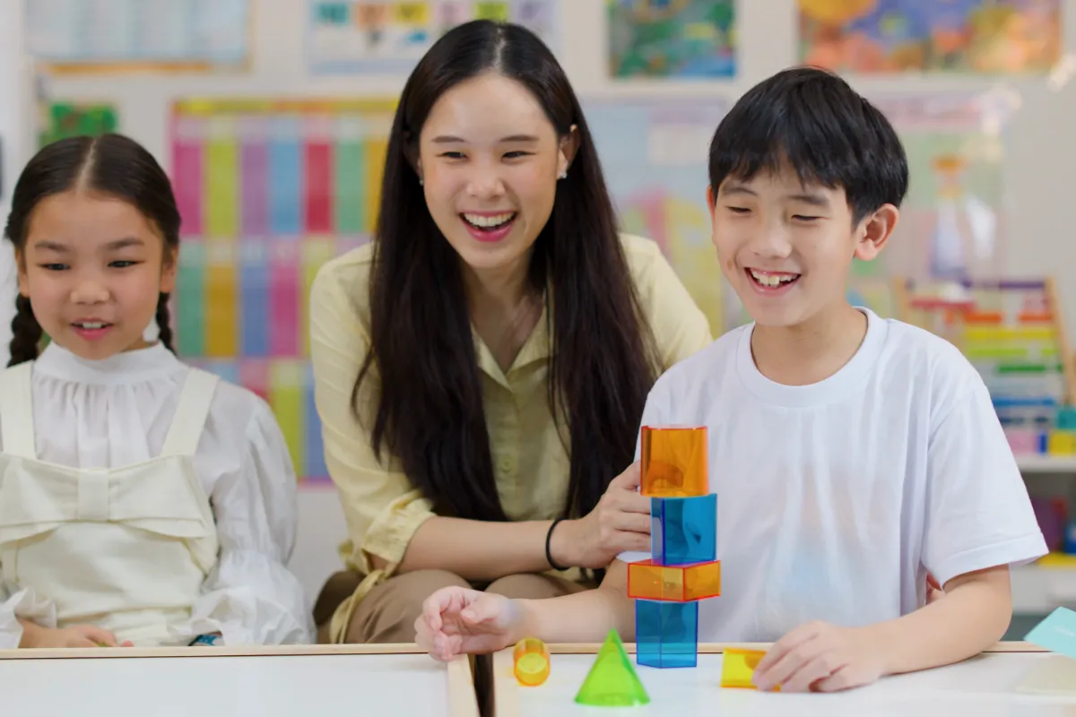 An Asian teacher working with a small group of students in a Singapore classroom