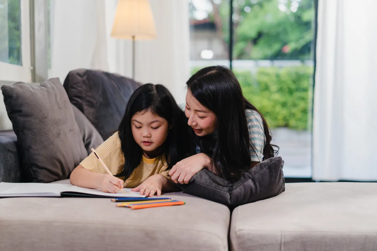 An Asian mother and daughter studying together at home in Singapore in the evening
