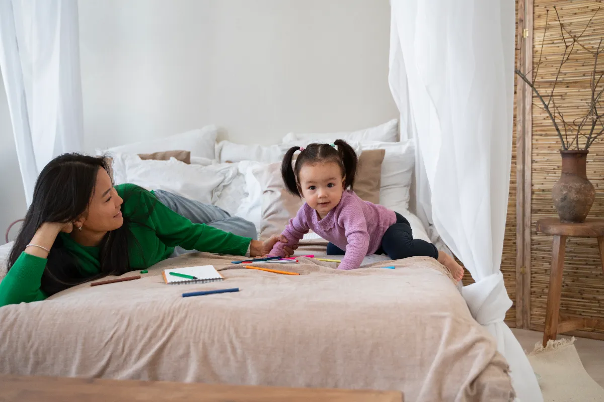 Asian mother and young daughter spending quality time together at home, engaged in a learning activity at a table in a warm Singapore home setting