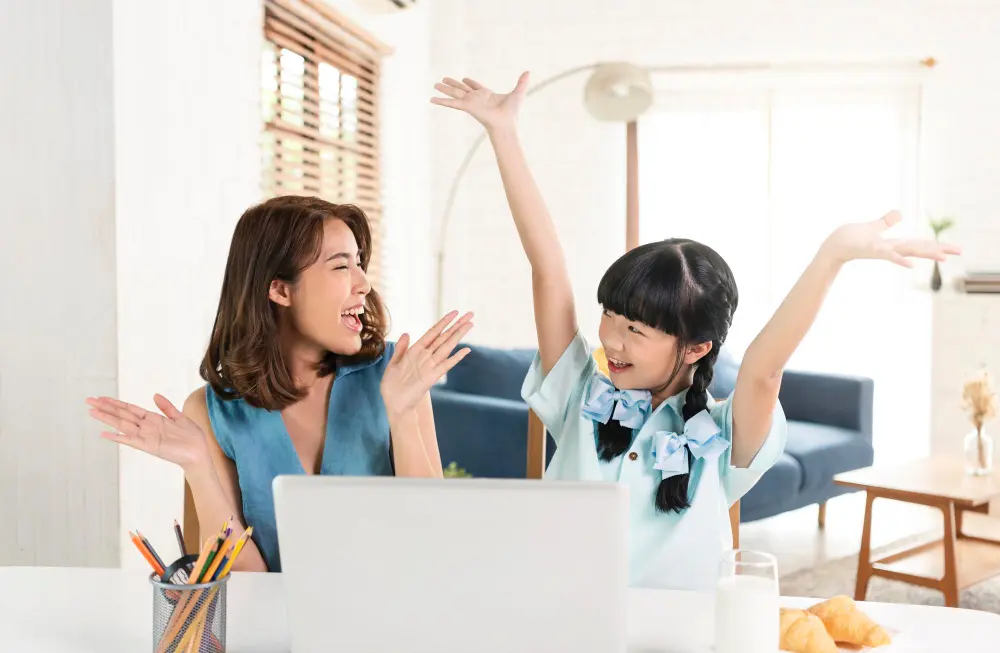 Mother and daughter celebrate with hands in the air, feeling positive.