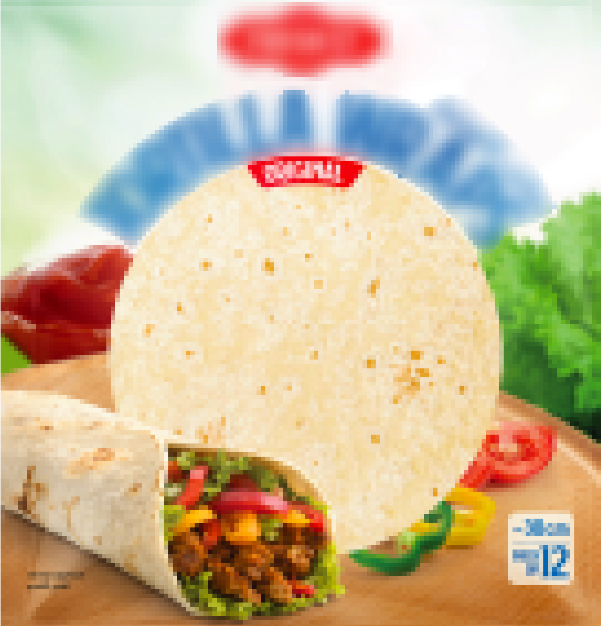 A wrap filled with lettuce, bell peppers, and meat beside a round flour tortilla on a wooden surface.