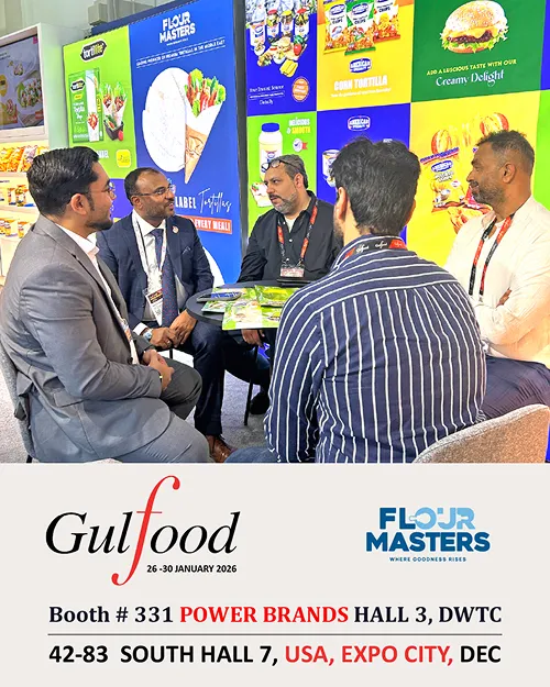 Five men in business attire seated around a table at a trade show booth with Flour Masters branding.