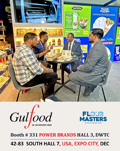 Four men seated at a round table discussing products in an exhibition booth with Flour Masters branding.
