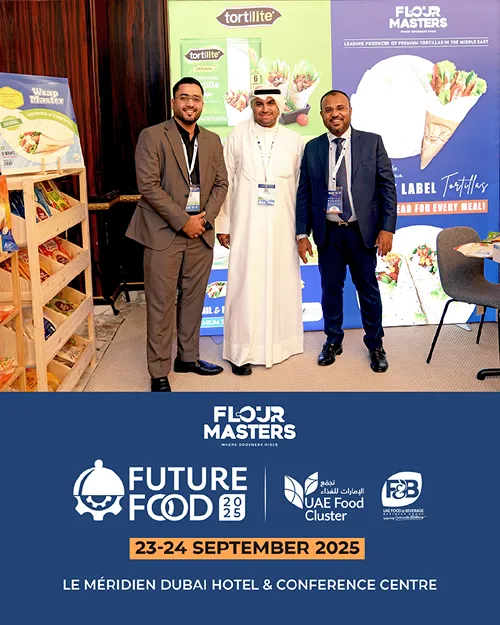 Three men in business attire posing at Future Food 2025 event with Flour Masters and UAE Food Cluster banners.