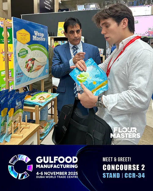 Two men discussing a product at a booth with Wrap Master display at Gulfood Manufacturing 2025.