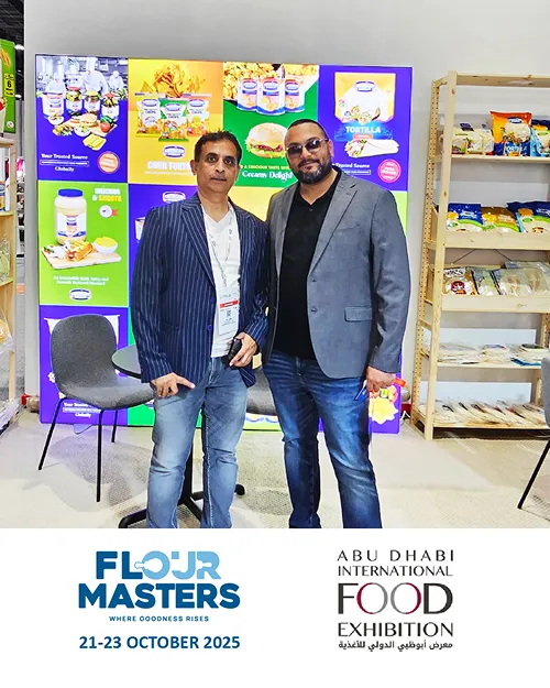 Two men standing in front of a colorful Flojr Masters promotional booth at Abu Dhabi Food Exhibition 2025.