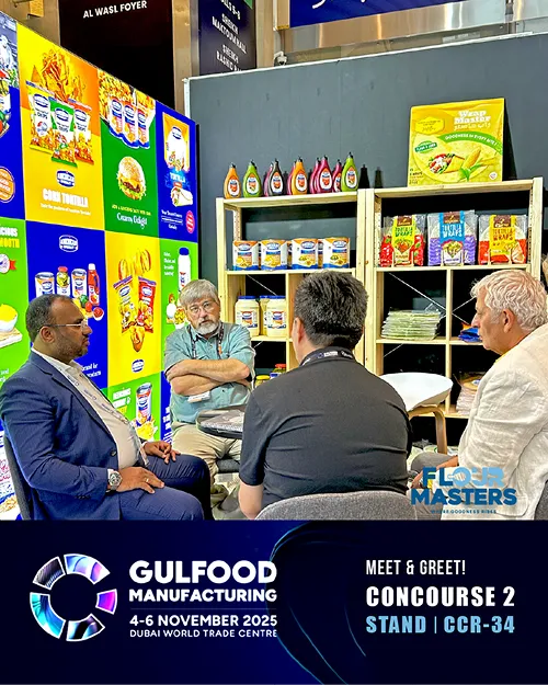 Four men seated and talking at a booth with grocery products at Gulfood Manufacturing event 2025 Dubai.