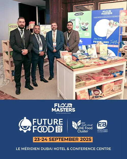 Four men in suits pose at Flour Masters booth with products at Future Food 2025 event in Dubai.