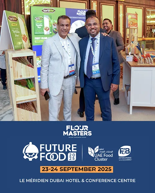 Two men posing at an event booth with Tortillite products and a Future Food 2025 conference banner.