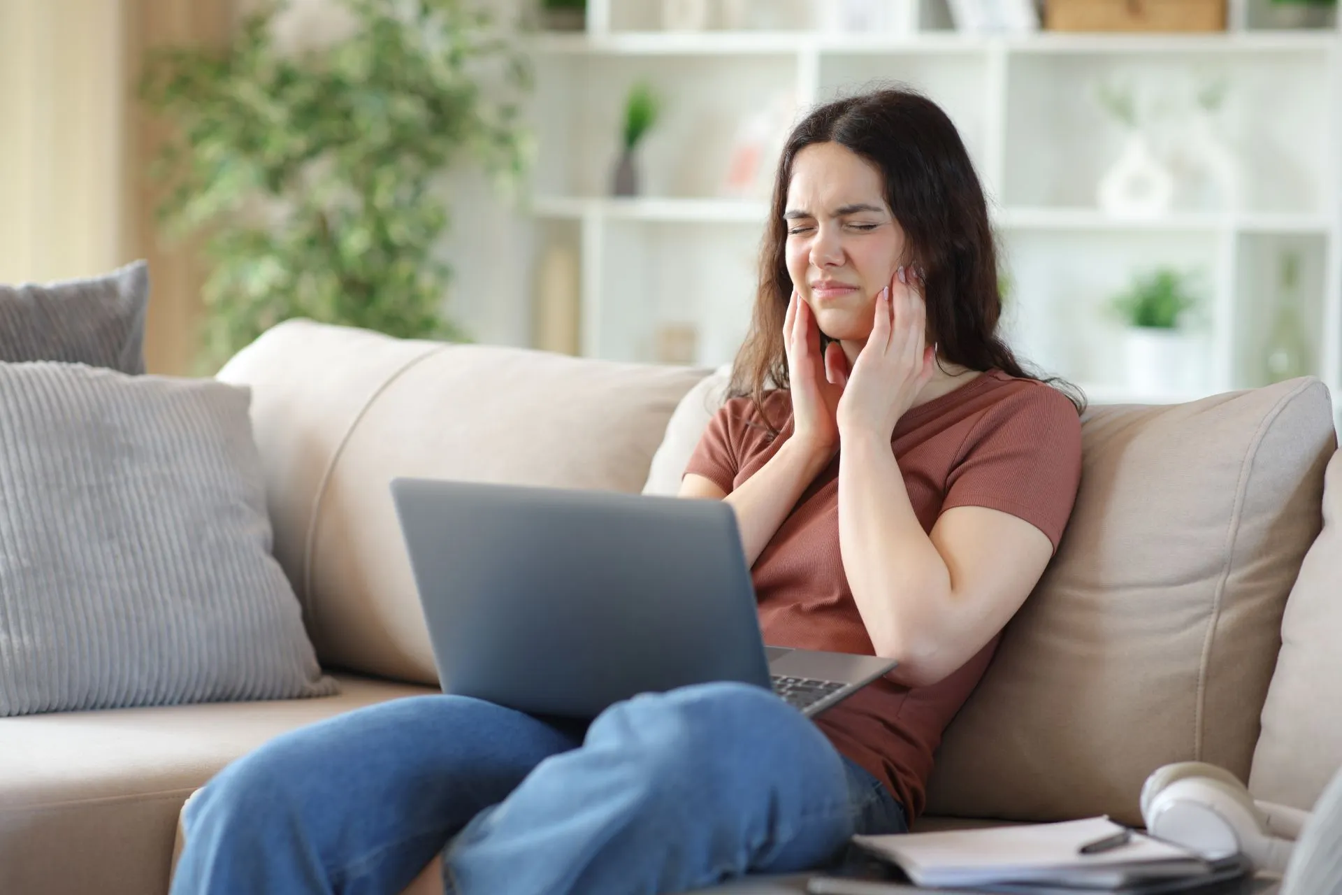 Patient holding jaw in discomfort due to TMJ pain before seeking treatment at Nova Dental Care of Chantilly
