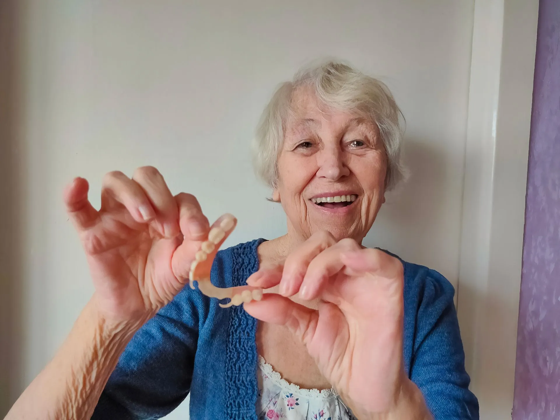 Patient smiling confidently with a stable, natural-looking implant-retained denture from Nova Dental Care of Chantilly