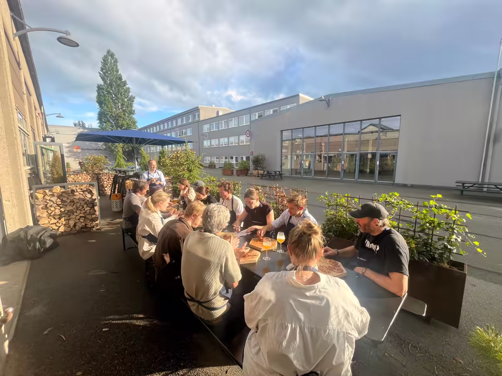 The Aegir Insights team having dinner around a long table in a Copenhagen courtyard in the evening sun