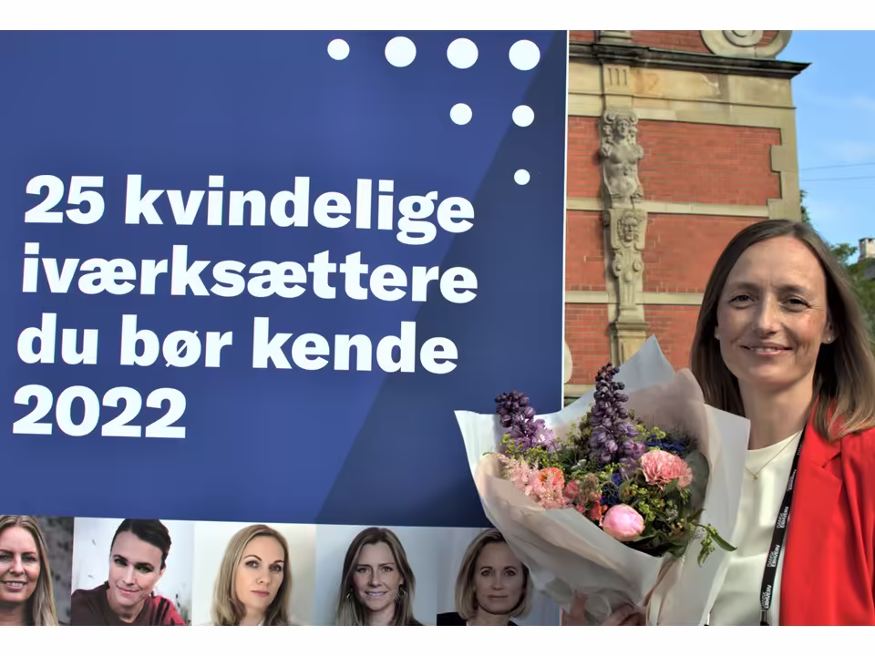 Rikke Nørgaard in front of a sign celebrating the list of 25 female entrepreneurs you should know, 2022, which she was on. The list recognizes female founders of successful businesses.