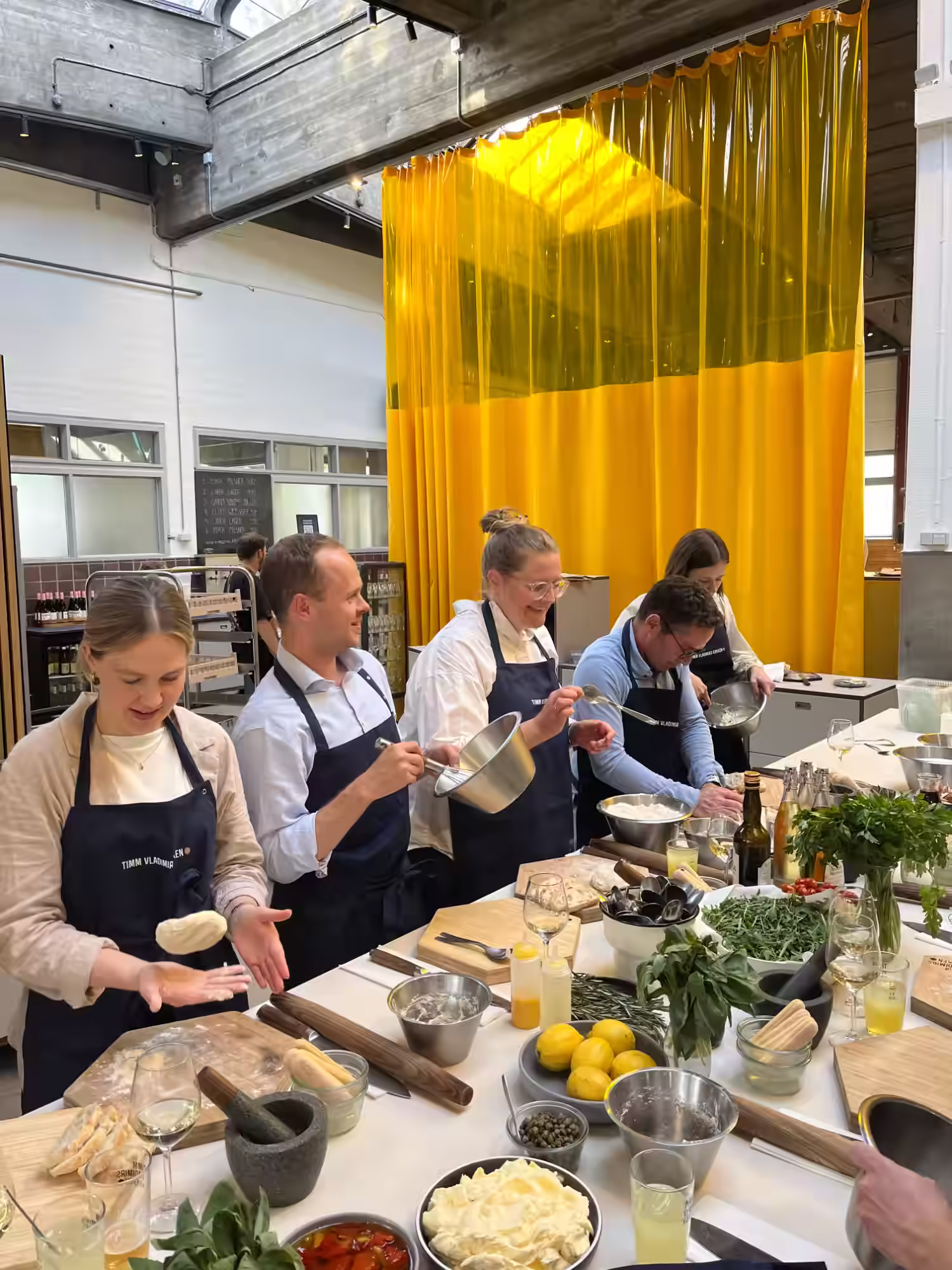Aegir Insights team members in Timm Vladimirs Køkken aprons preparing Italian food at a cooking class