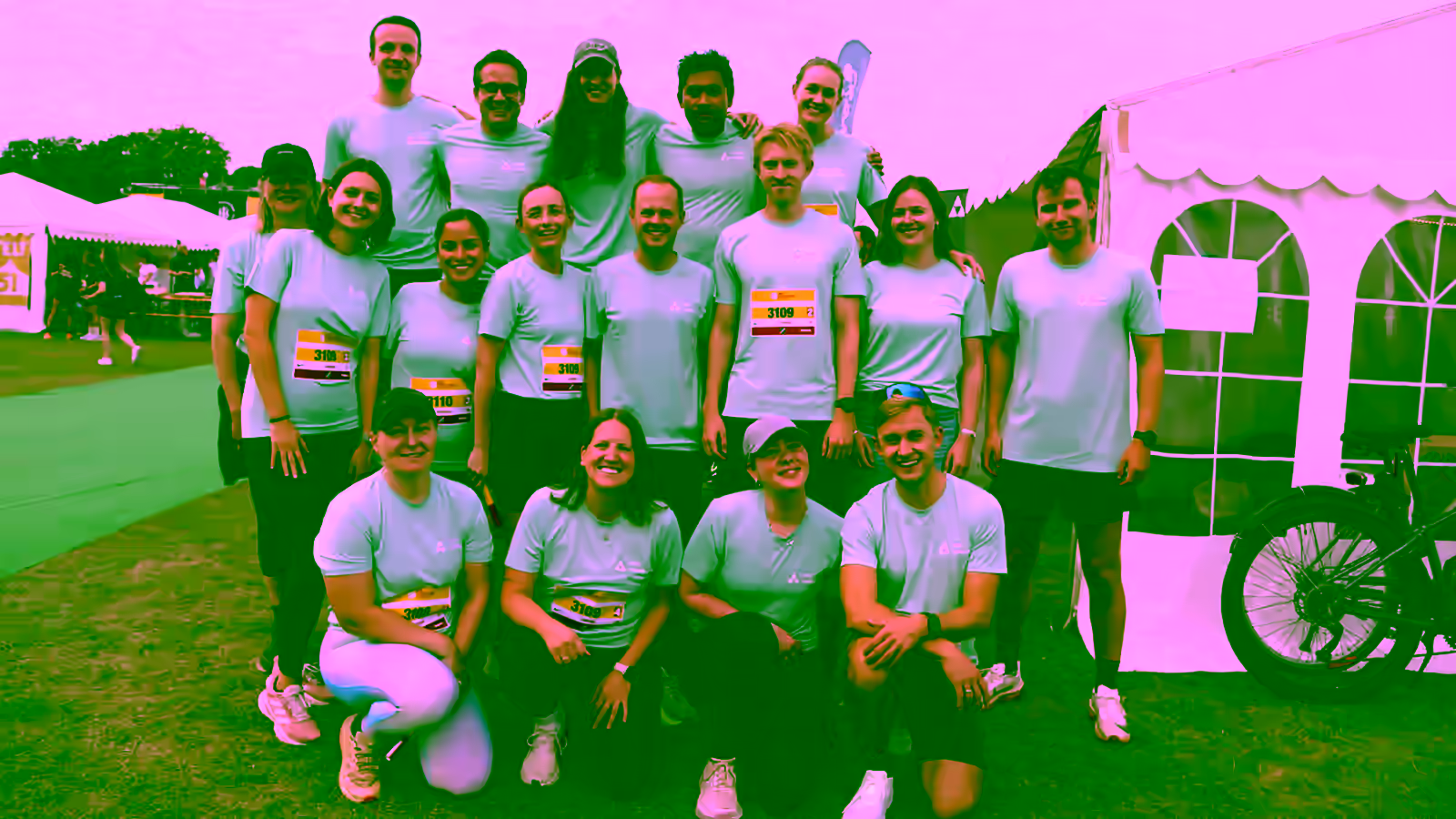 The Aegir Insights team in mint-green running shirts at the 2025 DHL relay run in Copenhagen, gathered on the grass in front of the race tents.