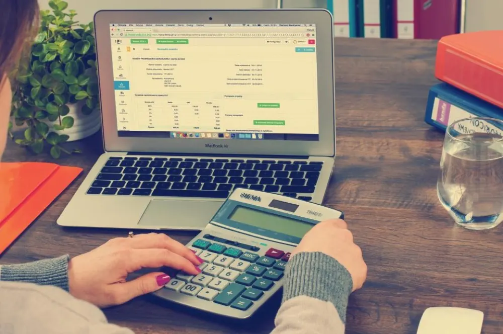 Comptable au travail sur un logiciel de gestion et une calculatrice