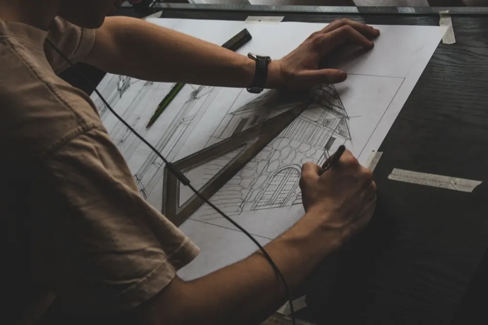 Architecte dessinant un plan à la main sur une table à dessin