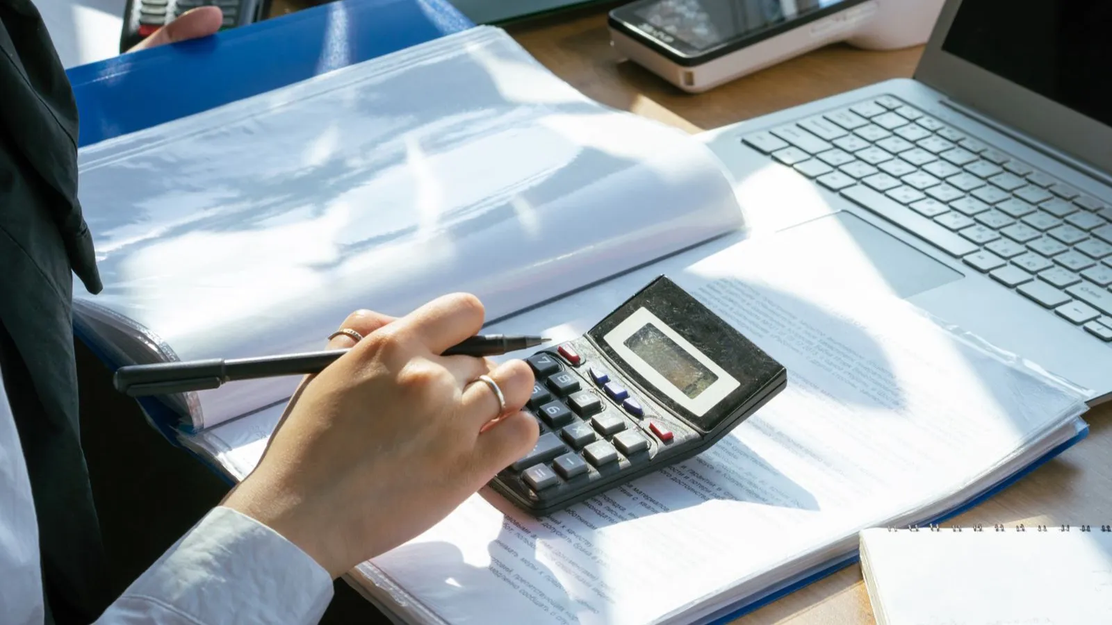 Comptable traitant des pièces justificatives avec calculatrice et classeur