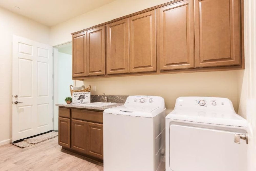 Laundry room with brown cabinets and white washer and dryer