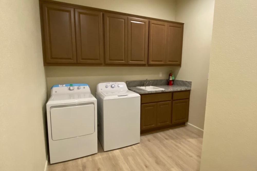 Laundry room with brown cabinets and white washer and dryer