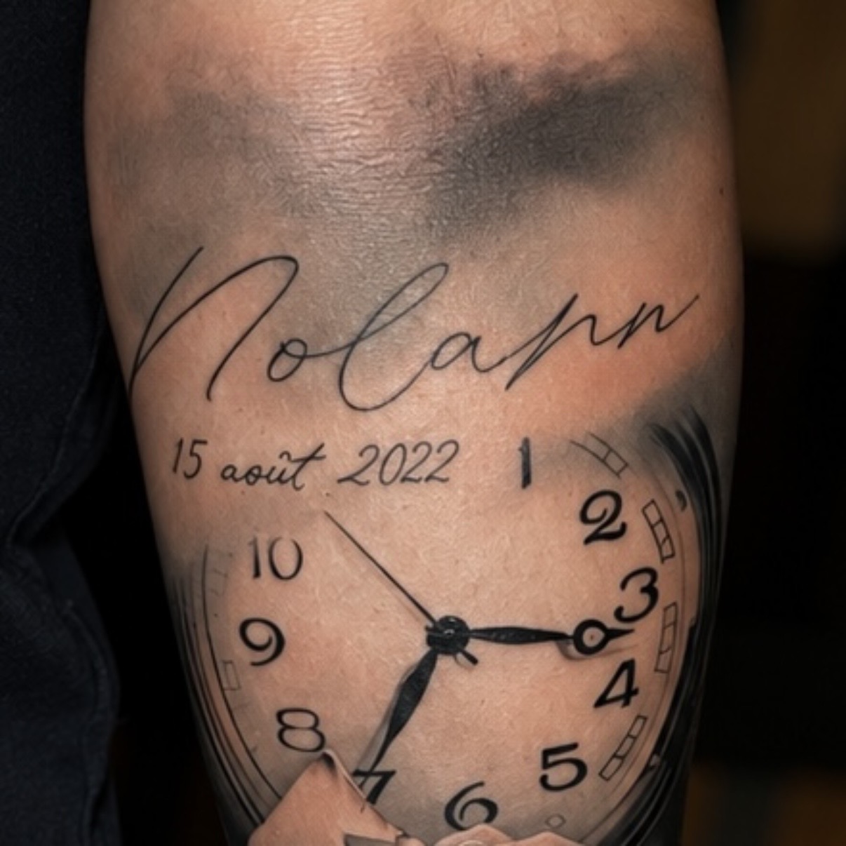 Tatouage d'horloge — détail du cadran et de l'inscription Nolann