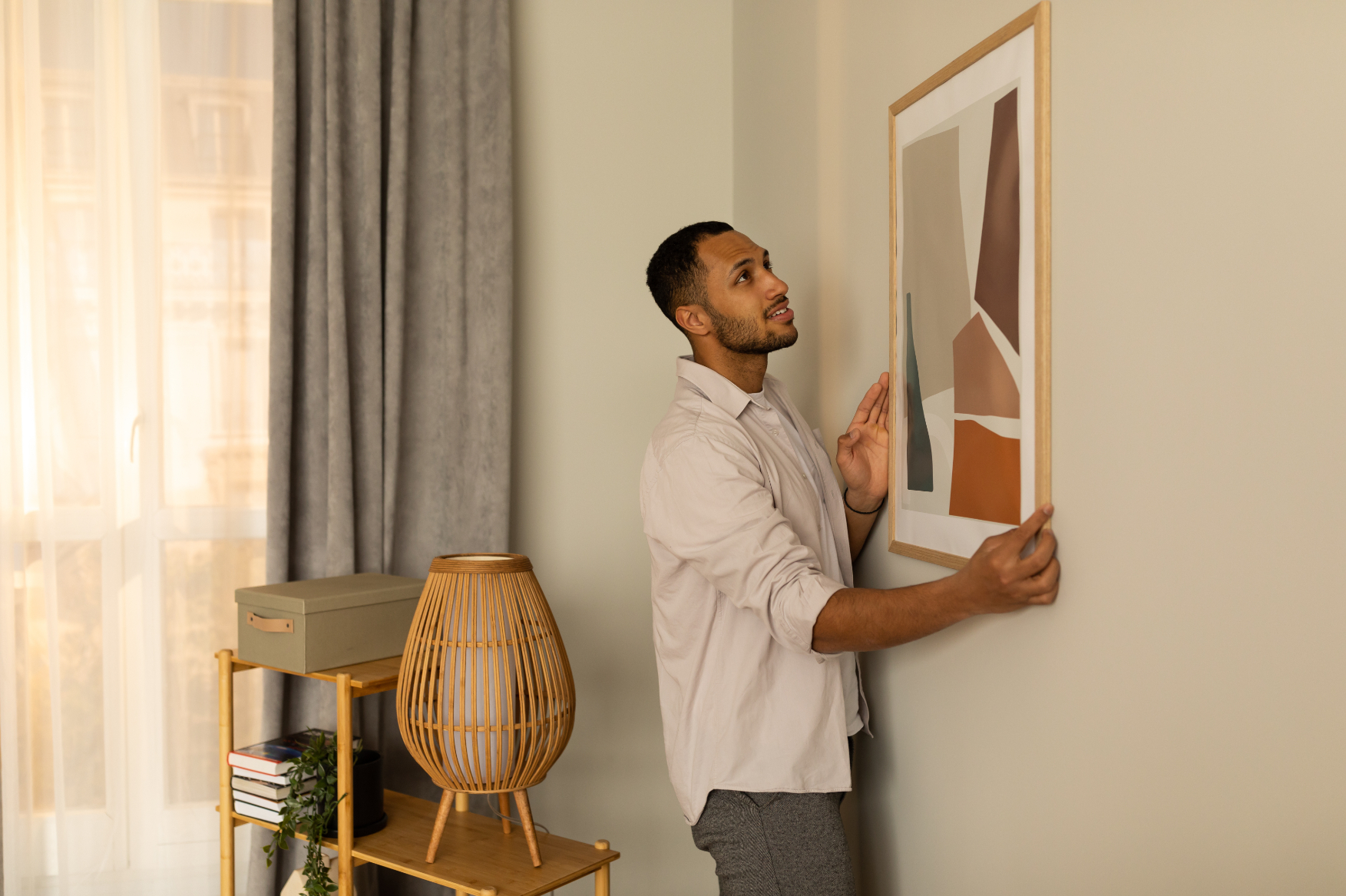 Man hanging picture on wall stock image