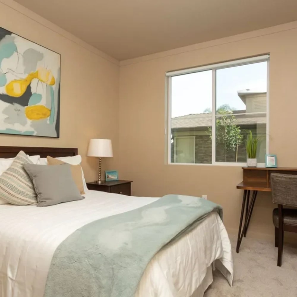 Bedroom with bed, desk, and large window 