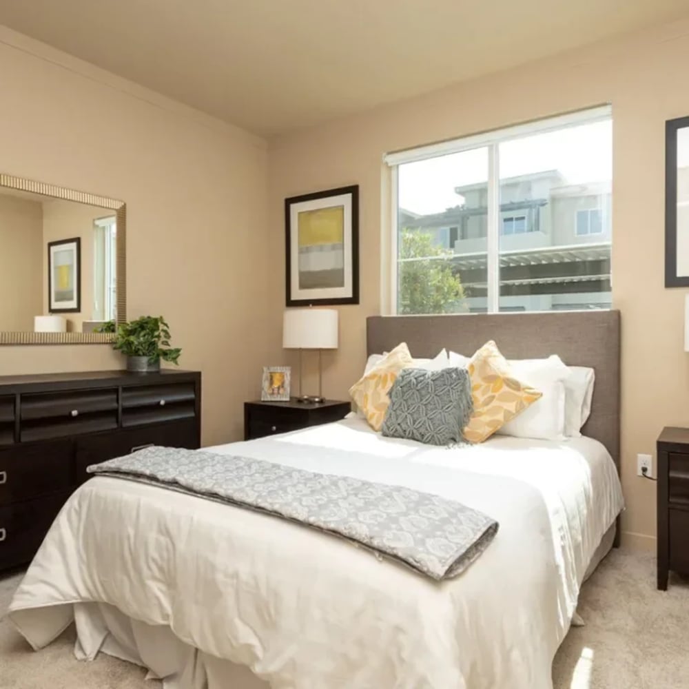 Bedroom with bed, dresser, and large window 