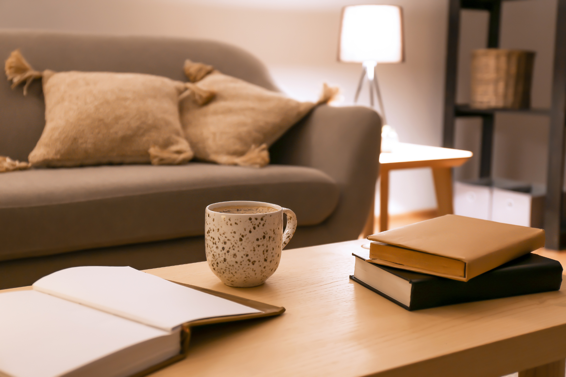 Living area with sofa, coffee table with coffee mug and books stock image