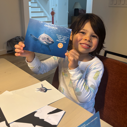 An Explorer beaming with their Quest 01 postcard