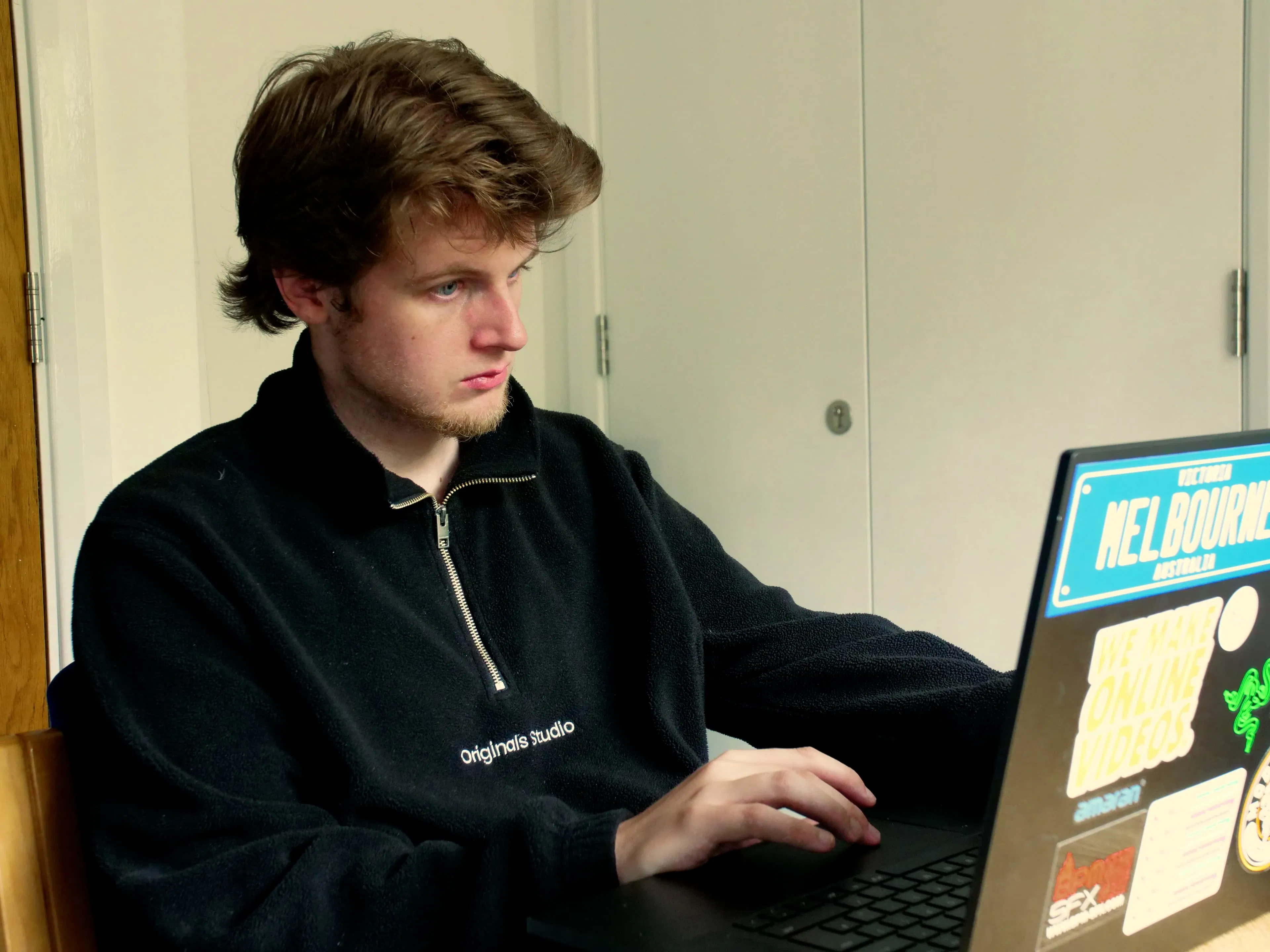 A Vault 5 Digital Marketing team member working intently on a laptop, managing charity advertising campaigns.