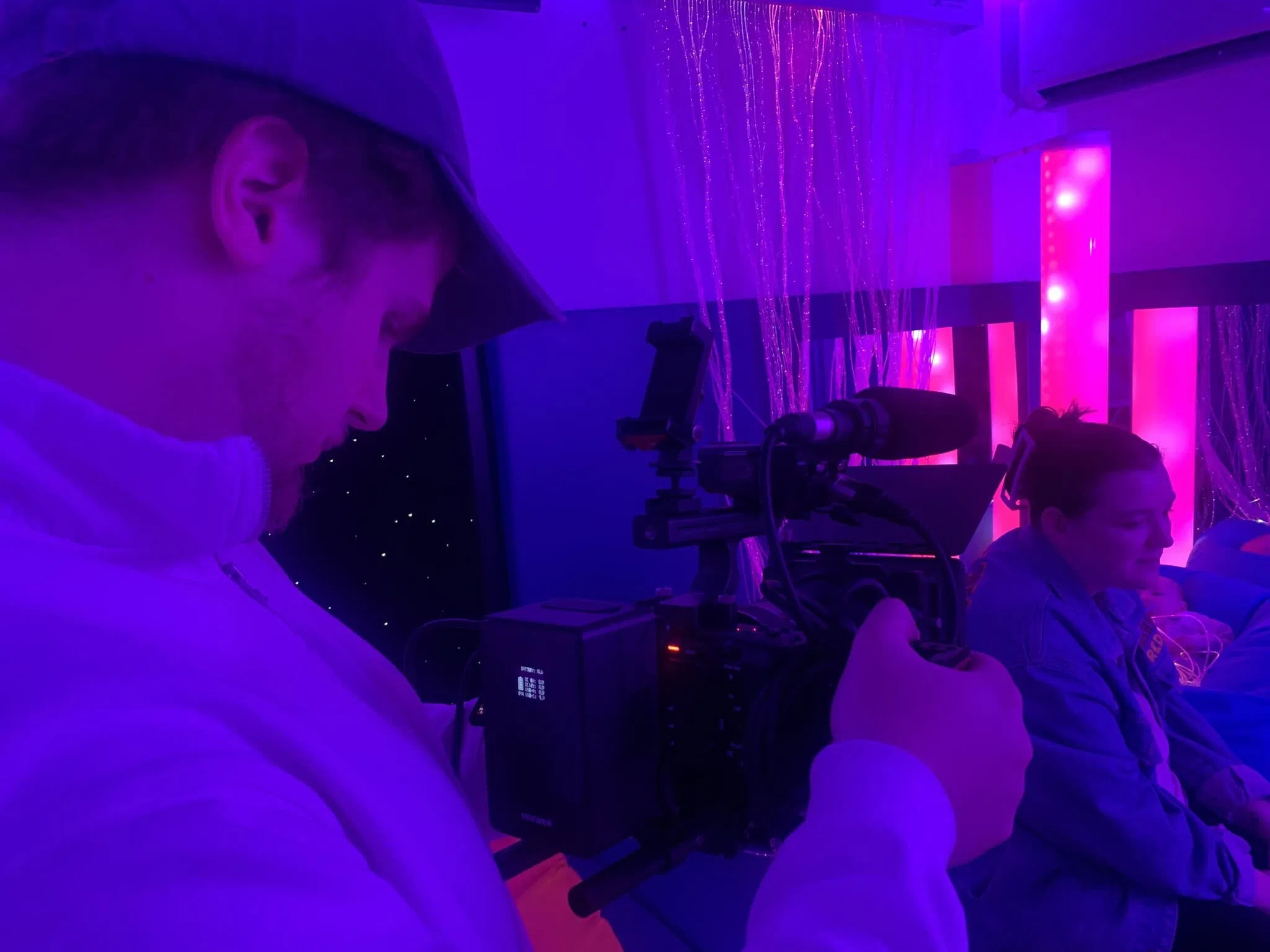 A professional videographer filming in our studio, highlighting the in-house capabilities Vault 5 offers to UK charities.