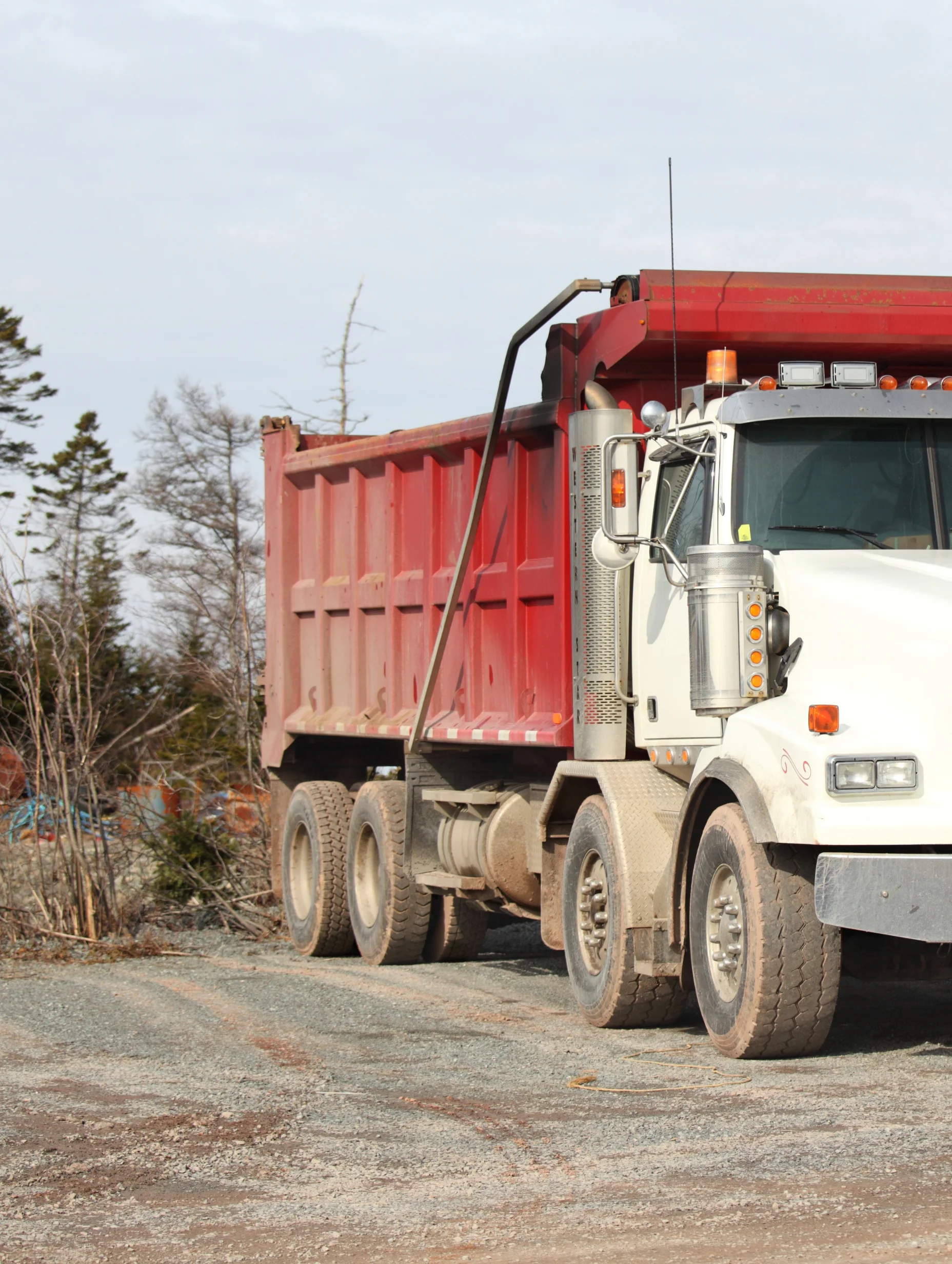 Hauler truck with a dirty red container on it