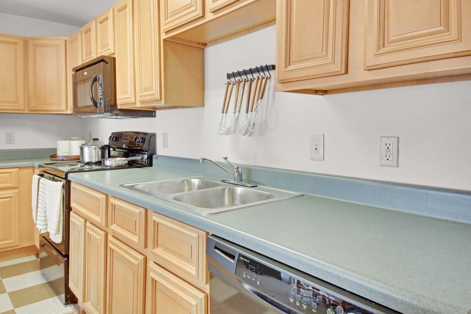Kitchen with brown cabinets and black appliances