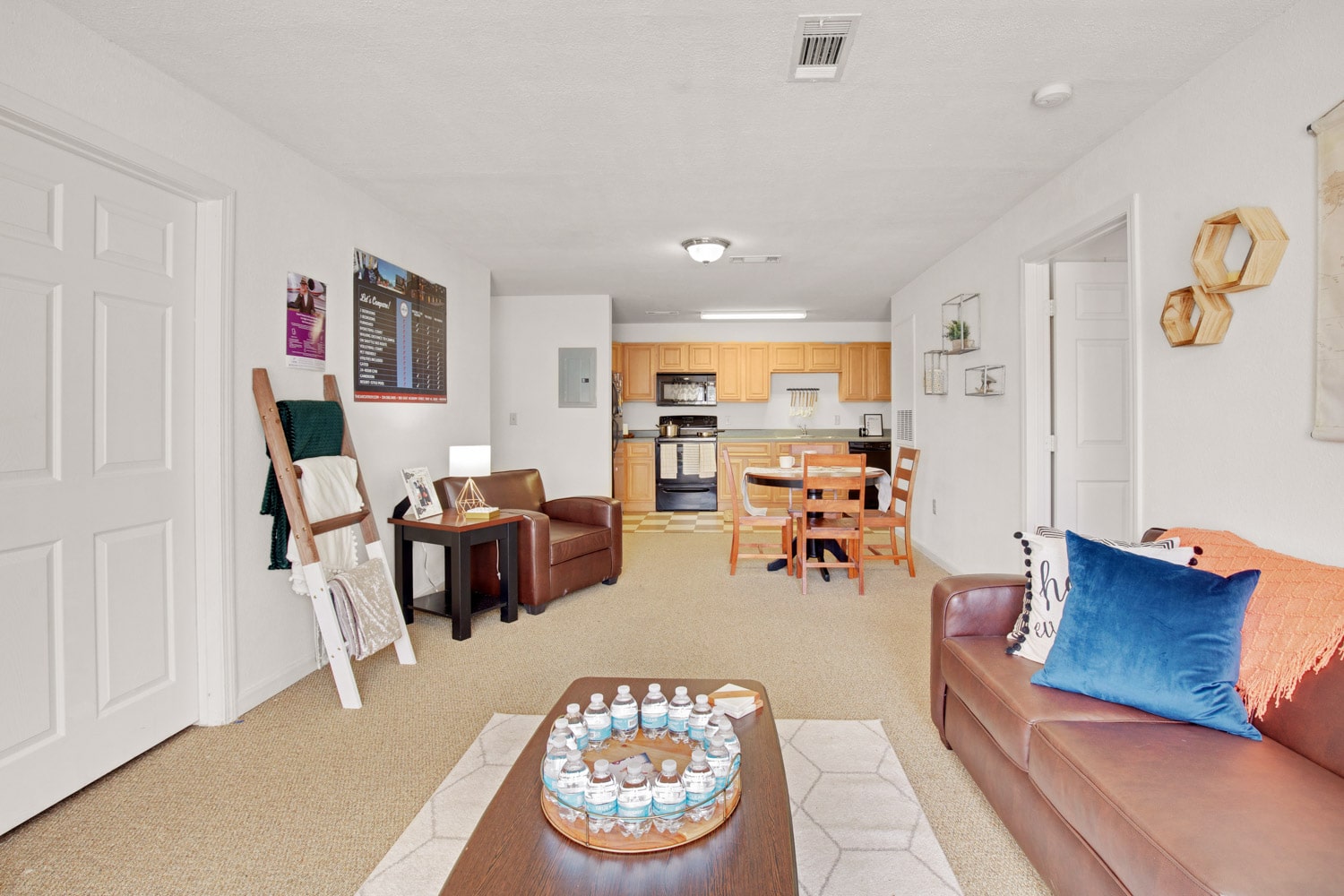 Wide view of Living area with sofa, coffee table, and view of dining area with table and chairs