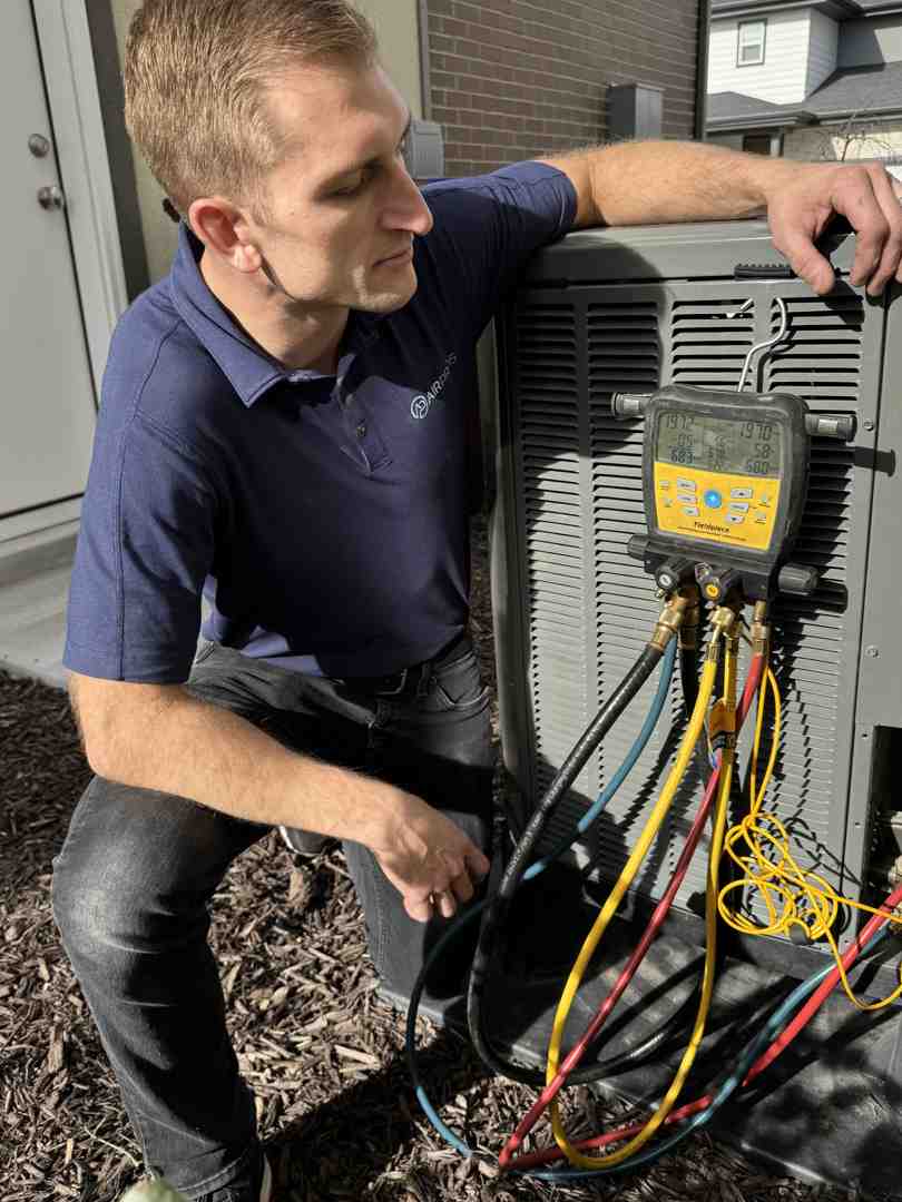 technician measuring refrigerant levels during ac tune-up - AC tune-up near me